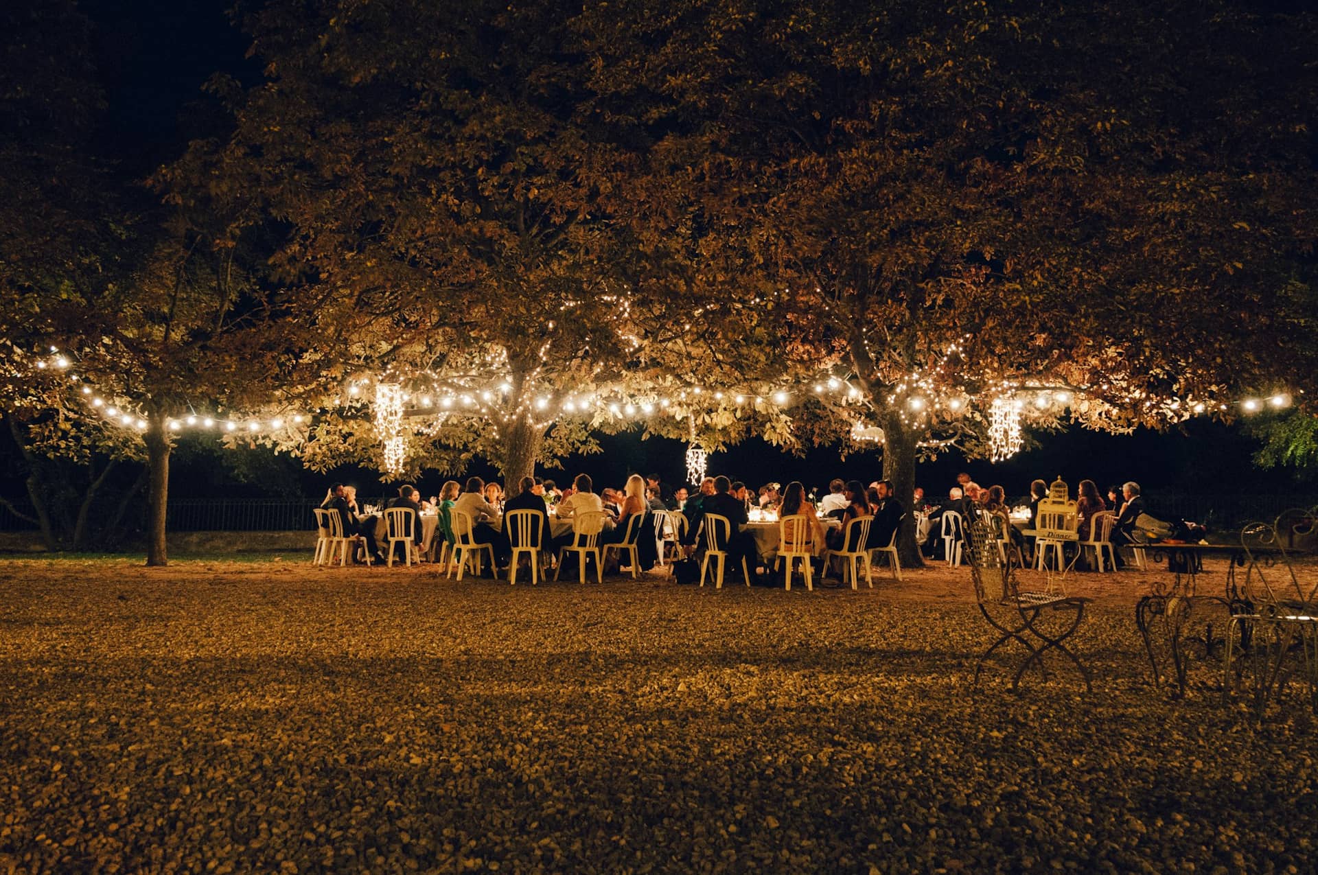 Guests under string lights at an evening reception